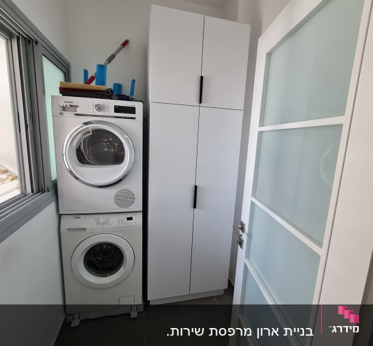 ארון לבן עם ידיות שחורות בחדר כביסה